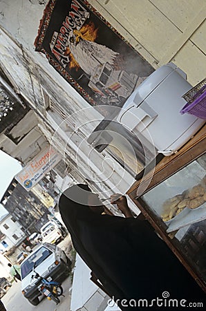 A women having a snack on a street, Zanzibar Editorial Stock Photo