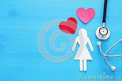 women healf Insurance . concept image of Stethoscope and female figure on wooden table. top view. Stock Photo