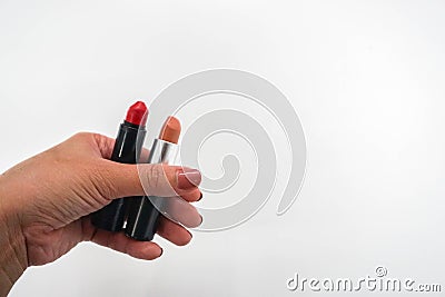 Women hold matte red and peach orange lipstick in hand for beauty Stock Photo