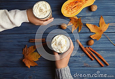 Women holding glasses with pumpkin spice latte Stock Photo