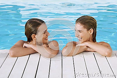 Women Leaning At Poolside Stock Photo