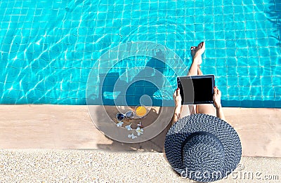 Women lifestyle play laptop relaxing near luxury swimming pool sunbath, summer day at the beach resort in the hotel. Stock Photo