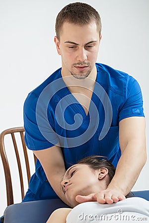 The woman is lying on the couch, and the doctor makes a diagnosis of the occipital part of the head. Manual therapy Stock Photo