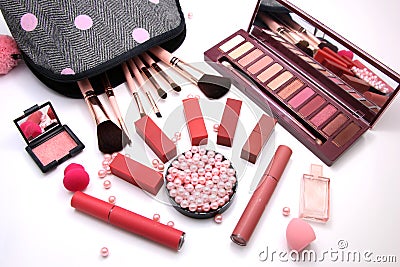 Women Make up Cosmetics bag and set of professional decorative, red lipsticks and brush makeup, perfume and sponge with pink pearl Stock Photo