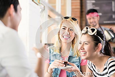 Women and man in Asian cafe drinking coffee Stock Photo