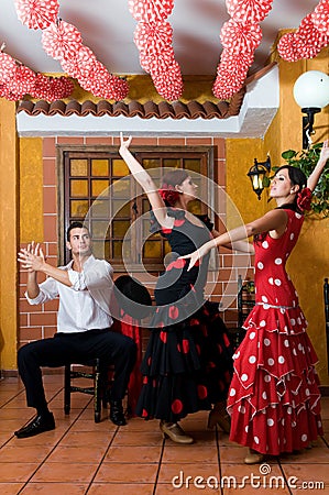 Women and man in traditional flamenco dresses dance during the Feria de Abril on April Spain Stock Photo