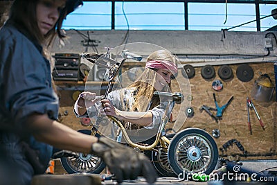 women mechanics repairing children bicycle in workshop Stock Photo