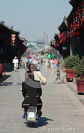 Women on moped in old town of Pingyao Editorial Stock Photo