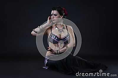 Women performs belly dance in ethnic dress on black background Stock Photo