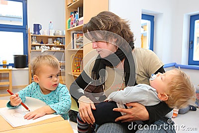 Women playing with kids in day care center Editorial Stock Photo