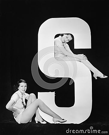 Women posing with huge letter S Stock Photo