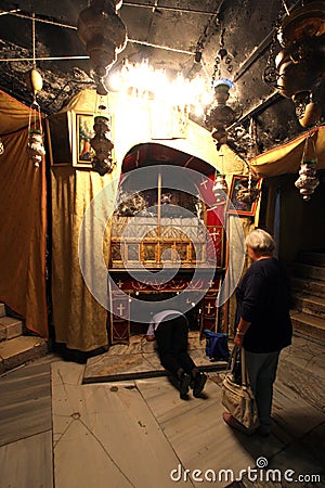 Women pray at the silver star marks the traditional site of Jesus` birth in a grotto underneath Bethlehem`s Church of the Nativity Editorial Stock Photo