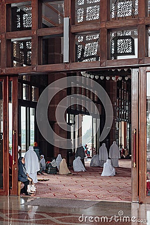 Women are praying in Putra Mosque in Wilayah Persekutuan Putrajaya, Malaysia Editorial Stock Photo