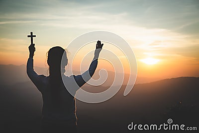 A women is praying to God on the mountain. Praying hands with faith in religion and belief in God on blessing background. Power of Stock Photo