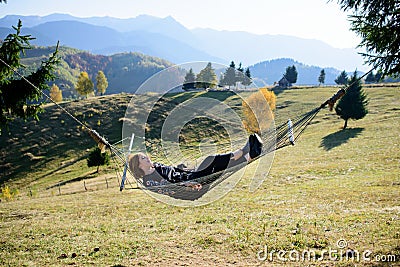 Women relaxing in hammock in autumn. mountain view Stock Photo