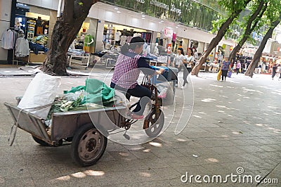 Women riding a tricycle Editorial Stock Photo