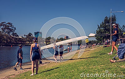 The women rowing team prepare to start with their boat on the bank of Yarra river Editorial Stock Photo