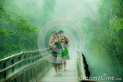 Women running in intensive rain, driving rain in rainforest near by Iguazu Falls, Brazil Editorial Stock Photo