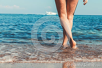 Women`s beautiful sexy legs on the beach Stock Photo