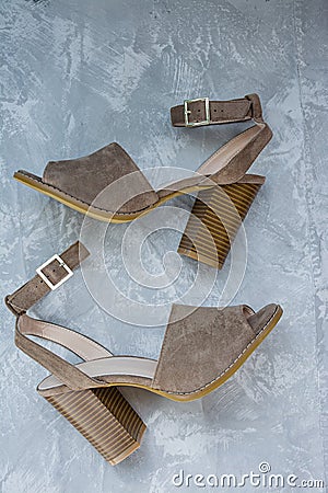 Women`s beige sandals. Summer footwear. Light background. Background under the concrete Stock Photo