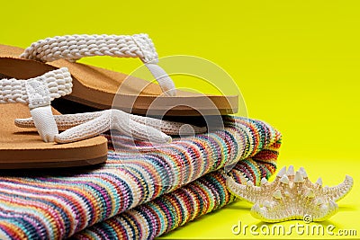 Women`s Causal Braided natural color Beach Flip Flops and Colorful Striped Beach Towels decorated with White Finger Starfish Stock Photo