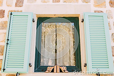 Women`s clogs with a large buckle on the side on the window with open shutters on the outside. Stock Photo