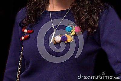 Women's dark purple sweater decorated with colored objects, soft toys on a pin, close-up on a black background Stock Photo