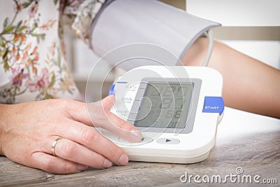 Checking blood pressure at home Stock Photo