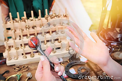 In women`s hands a big hairpin in the form of a stick stone. Fantastic hair clip with a large jasper staff Stock Photo