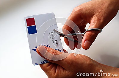 Women`s hands cut a plastic card with iron scissors Stock Photo