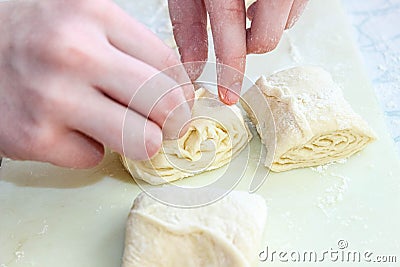 Women`s hands from yeast dough cook buns of different shapes Stock Photo