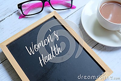 Women`s health written on a blackboard. Stock Photo