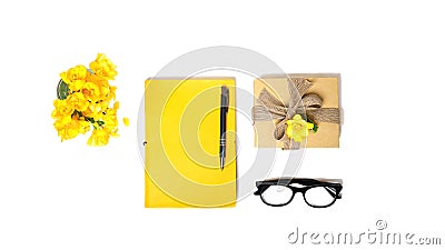 Women`s home office desk. Workspace with yellow notebook, fashion glasses carton box fot gift, flower on white background. Flat Stock Photo