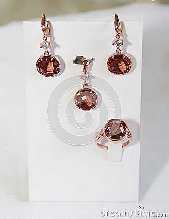 Women`s jewelry set of gold earrings and neck pendants with precious stones Stock Photo