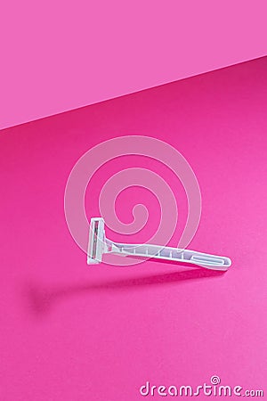 Women`s plastic razor on a bright pink isothermal background. Stock Photo