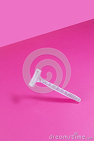 Women`s plastic razor on a bright pink isothermal background. Stock Photo