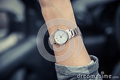 Women`s wristwatch on the girl`s hand. Women`s gold watch. Time is money Stock Photo