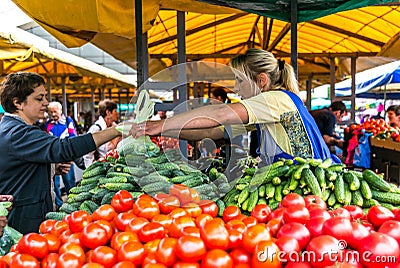 Women sell on the market ripe vegetables, onions, peppers, cucumber, greens Editorial Stock Photo