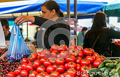 Women sell on the market ripe vegetables, onions, peppers, cucumber, greens Editorial Stock Photo