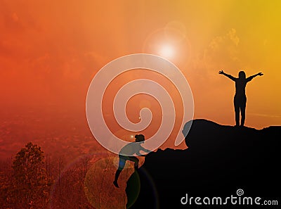 Women silhouette climbing and standing on cliff with blurred cit Stock Photo