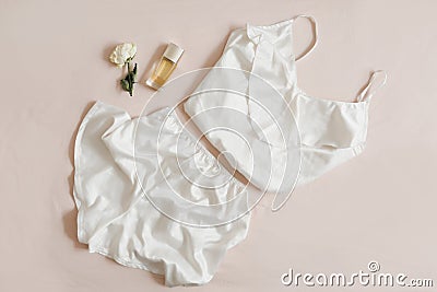 Women silk lingerie on beige background top view, flatlay. Female lace nightwear clothes Stock Photo