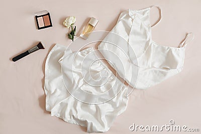 Women silk lingerie on beige background top view, flatlay. Female lace nightwear clothes Stock Photo