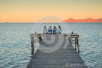 Women sitting on the pier and talk together. Mallorca, Spain. summer vacation with friends Editorial Stock Photo