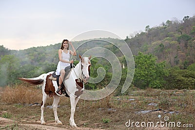 Women on skirt dress Riding Horses On field landscape Against forest. Stock Photo