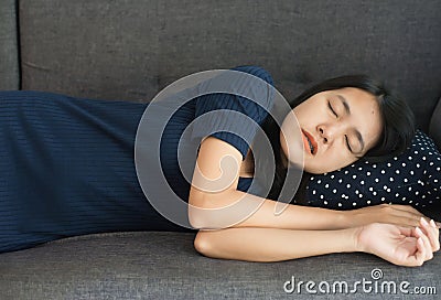 Women sleeping on sofa bed and grinding teeth,Female tiredness and stress at living room Stock Photo