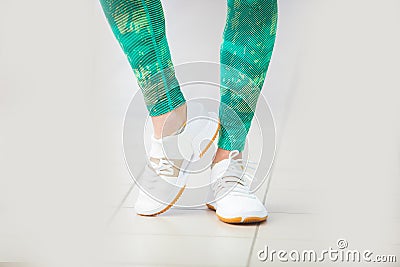 Women slender legs in sports leggings and sneakers in the gym. Stock Photo