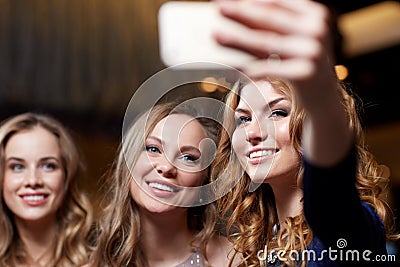 Women with smartphone taking selfie at night club Stock Photo