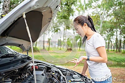 Women spection. She opened the hood Broken car on the side See engines that are damaged or not Stock Photo