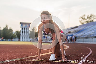 Women sprinters at starting position ready for race on racetrack. Stock Photo