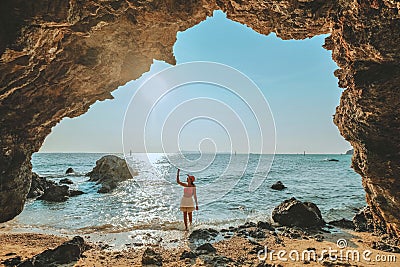 Women standing on a rock at the cave entrance Look at the sea and beautiful views. at sunset romantic atmosphere at Kho Larn , Stock Photo